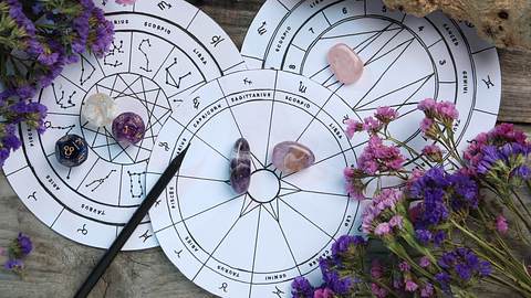 Astrologische Zeichnungen sind umgeben von Frühlingsblumen und Edelsteinen - Foto: Liudmila Chernetska / iStock