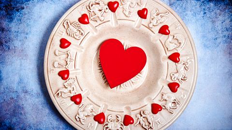 Rote Herzen auf einer Scheibe mit Sternzeichen-Symbolen - Foto: starblue / AdobeStock