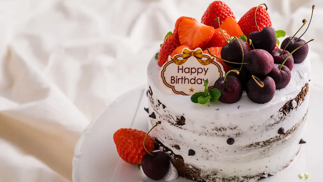 Geburtstagstorte mit Erdbeeren, Kirschen und einem Happy-Birthday-Schild - Foto: Hide_Studio / AdobeStock Geburtstagstorte mit Erdbeeren, Kirschen und einem Happy-Birthday-Schild - Foto: Hide_Studio / AdobeStock