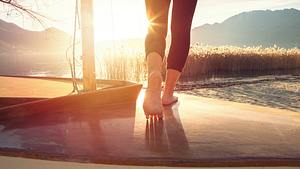 Eine Frau läuft Barfuß über ein Boot - Foto: swissmediavision / iStock