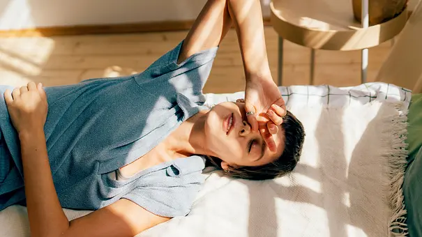 Frau liegt auf ihrem Bett und liegt ihre Hand auf ihrer Stirn ab - Foto: Ilona / AdobeStock Frau liegt auf ihrem Bett und liegt ihre Hand auf ihrer Stirn ab - Foto: Ilona / AdobeStock