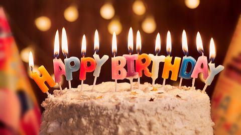 Geburtstagstorte mit bunten Kerzen im Schriftzug Happy Birthday - Foto: Lacheev / iStock