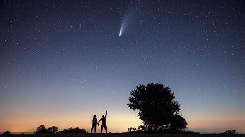 Zwei Menschen beobachten eine Sternschnuppe am Nachthimmel - Foto: Revolu7ion93 / iStock