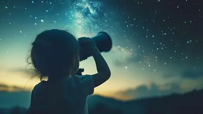 Mädchen guckt durch ein Fernglas in den Nachthimmel - Foto: VK Studio / AdobeStock
