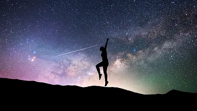 Silhouette einer Frau die vor einem Sternenhimmel tanzt - Foto: Inga-Av/iStock