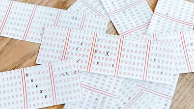 Lotto-Scheine auf einem Holztisch - Foto: LIGHTFIELD STUDIOS / AdobeStock
