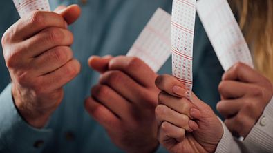 Zwei Personen halten Lotto-Scheine hoch - Foto: LIGHTFIELD STUDIOS / AdobeStock