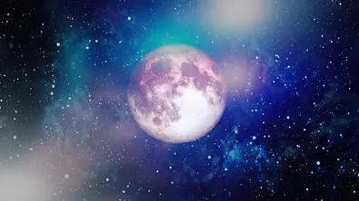 Der Vollmond umgeben von einer leuchtenden Galaxie - Foto: Maximusnd/iStock