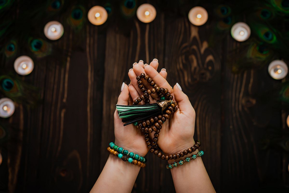 Frau hält buddhistisches Mala in der Hand