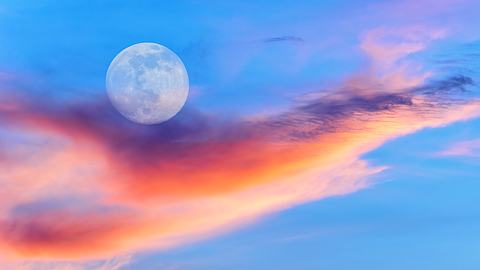 Ein leuchtender Vollmond steht am Himmel bei Sonnenuntergang - Foto: David Baileys/iStock