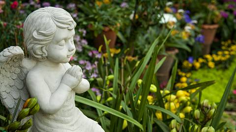 Statue eines betenden Engels in einem Garten - Foto: iStock/pattamod