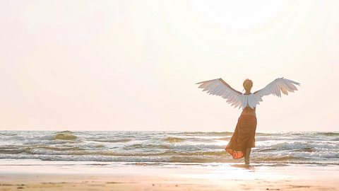 Frau mit Engelsflügeln am Strand - Foto: Alexeg84/iStock