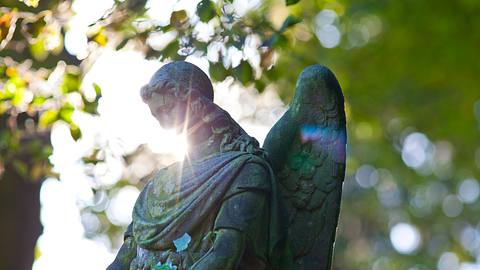 Engelstatue mit Sonne im Hintergrund - Foto: iStock/horstgerlach