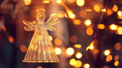 Weihnachtengel aus Glas umgeben von Lichtern - Foto: marcelmondocko / AdobeStock