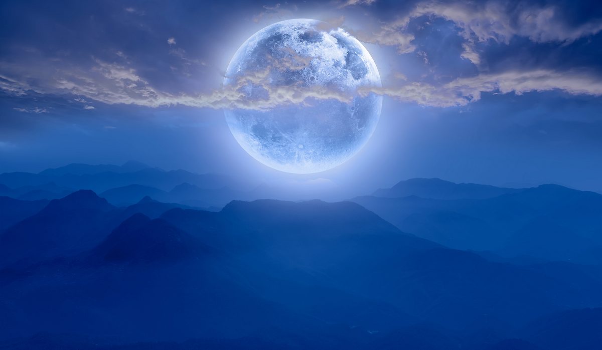 Vollmond steht über einer Berglandschaft