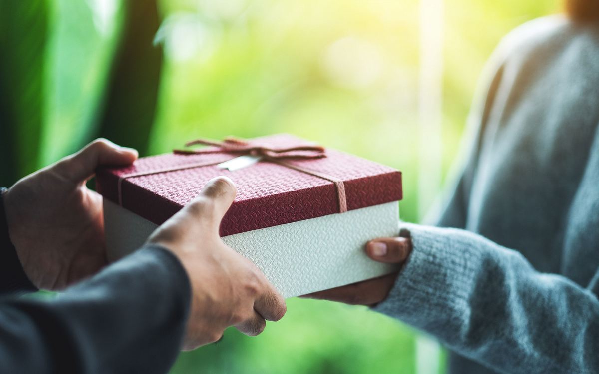 Mann übergibt Frau ein Geburtstagsgeschenk