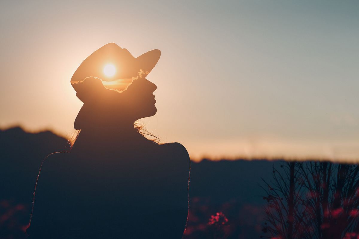 Frau mit Hut hat die Sonne in ihren Gedanken