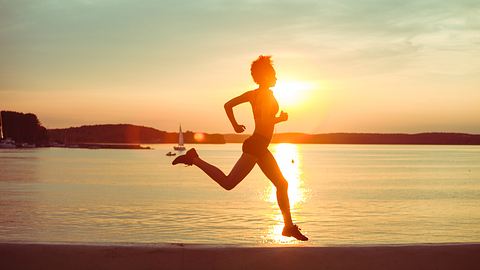 Junge Frau joggt bei Sonnenuntergang - Foto: uzhursky / iStock