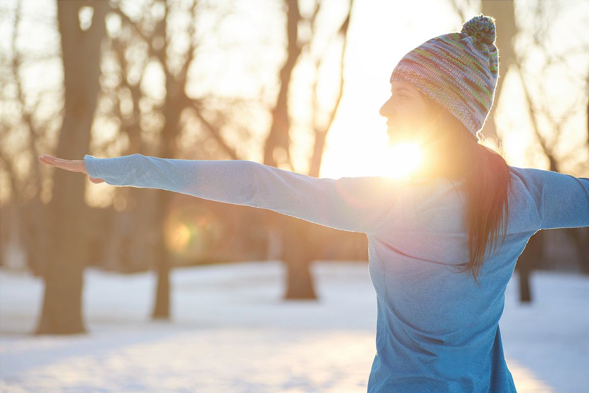 Frau streckt sich im Winter draußen 