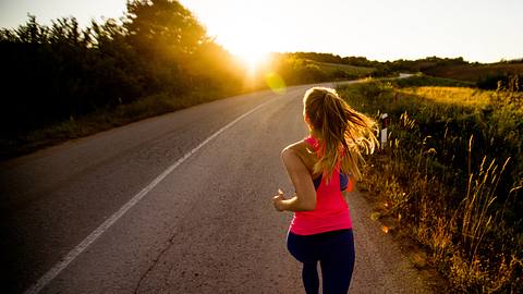 Junge Frau geht beim Sonnenuntergang joggen - Foto: freemixer / iStock