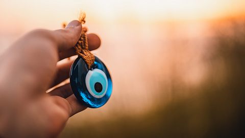 Eine Hand hält ein Nazar-Amulett - Foto: Sefa kart / iStock