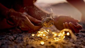 Aromatherapie am Strand mit Salbeirauch und einer Lichterkette - Foto: Jacob Wackerhausen / iStock