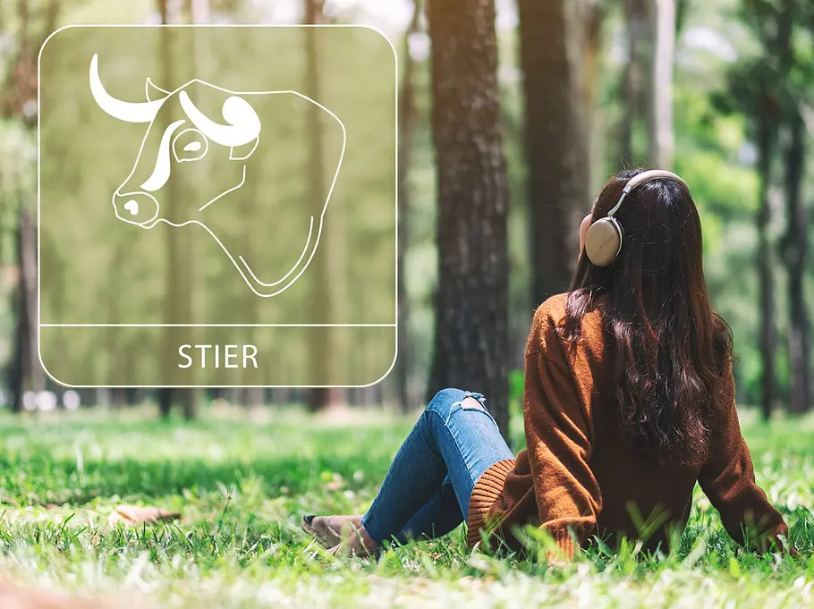 Frau mit Kopfhörern in einem sonnigen Wand neben dem Sternzeichen Stier