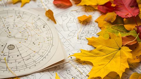 Astrologische Zeichnungen auf denen Herbstblätter liegen - Foto: Blazenka / Adobe Stock