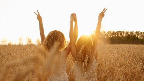 zwei Mädchen in der Sonne im Feld - Foto: iStock/jeffbergen