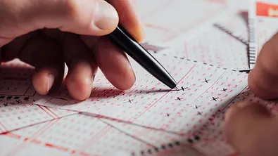 Lotto Schein wird mit einem Kugelschreiber ausgefüllt - Foto: LIGHTFIELD STUDIOS / AdobeStock