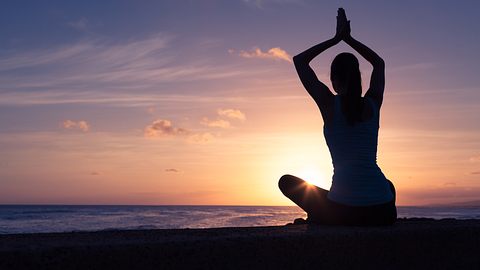 Frau die Yoga macht am Strand - Foto: kieferpix/iStock