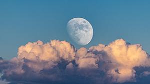Der Mond steht am blauen Himmel vor einer Wolke - Foto: Agustin Ferreiro Abelairas/iStock