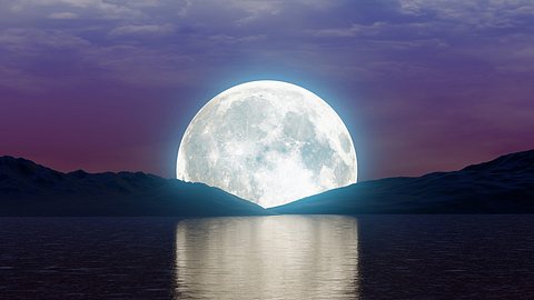 Mond hinter See und Bergen - Foto: jacquesdurocher/iStock