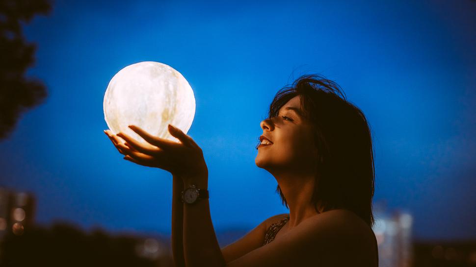 Frau hält Mondlampe in den Händen - Foto: urbazon/iStock
