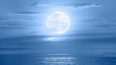 Nachthimmel mit Vollmond in den Wolken über dem Meer - Foto: murat4art / iStock