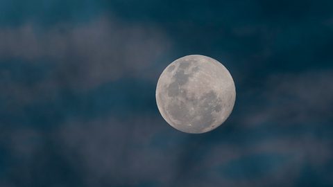 Vollmond steht am Himmel umgeben von Wolken - Foto: Foto4440 / iStock 