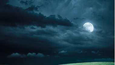 Mond am Nachthimmel über einer Wiese - Foto: iStock/spooh