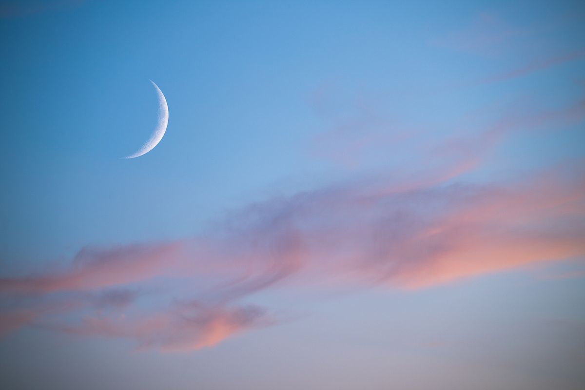 Dünne Mondsichel in einem blauen Himmel. 