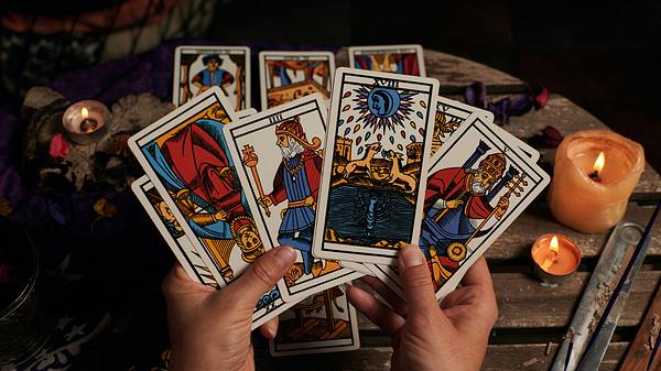 Zwei Hände halten mehrere Tarotkarten - Foto: iStock/Cristian Blázquez Martínez